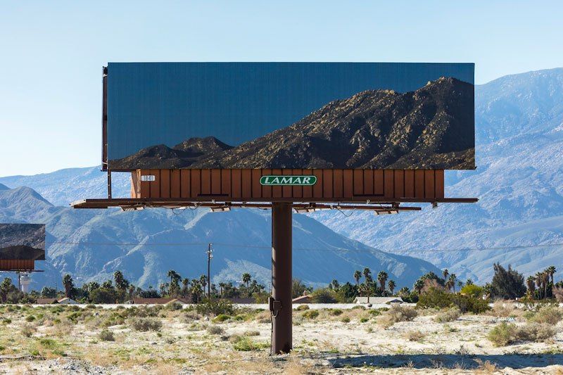 Художник заклеивает билборды пейзажами, которые те перекрывают