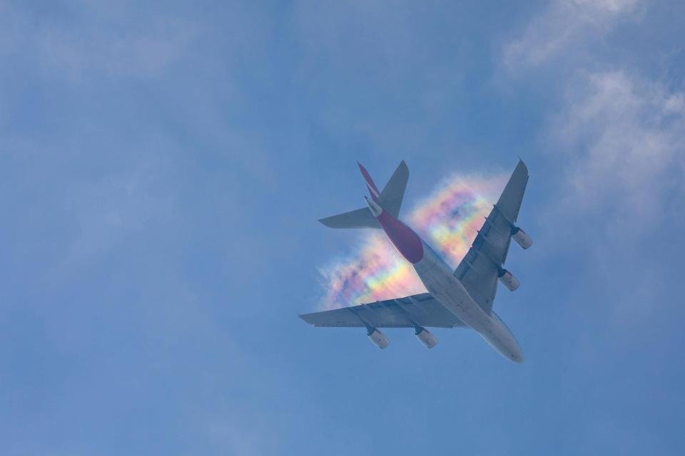 Радужный след в небе над самолетом
