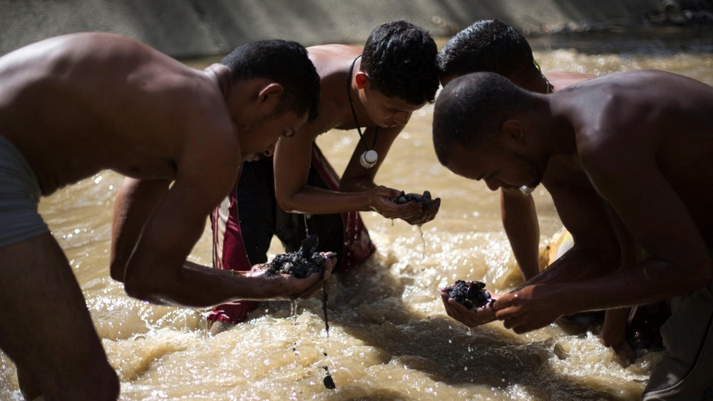 Молодые венесуэльцы ищут металл в реке