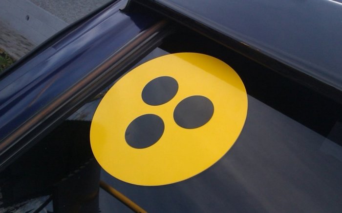 Что означает желтый круг с черными точками на автомобиле